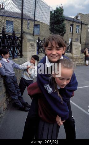 Ragazze che giocano nel campo da gioco della scuola primaria; Regno Unito Foto Stock