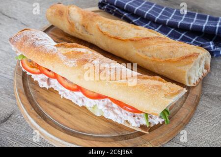 panino di tonno e verdure crude su un tagliere Foto Stock