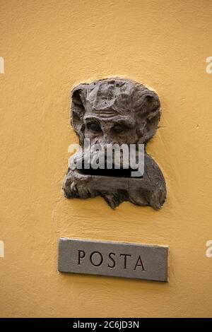 Spazio vuoto per la casella postale vintage sulla vecchia parete dell'edificio. Slot con iscrizione POSTA o Mail su piatto metallico e bizzarra testa di creatura irriconoscibile Foto Stock