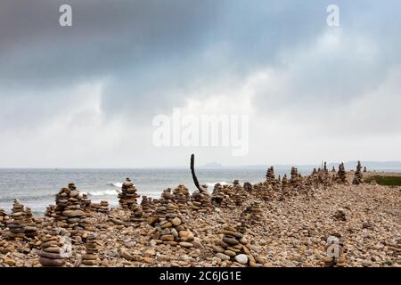 Cairns on Castle Point, Holy Island of Lindisfarne, Northumberland, Inghilterra, UK: In conflitto con l'etica Leave No Trace Foto Stock