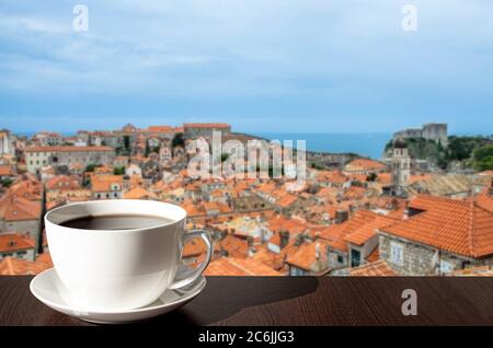 Tazza bianca di porcellana di caffè o tè con il paesaggio mediterraneo della città di Dubrovnik, Croazia. Vista dall'alto dei tetti rossi, centro storico Foto Stock