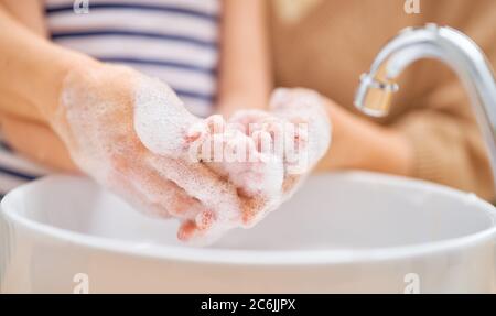 Bambini e adulti si lavano le mani. Protezione contro infezioni e virus. Primo piano. Foto Stock