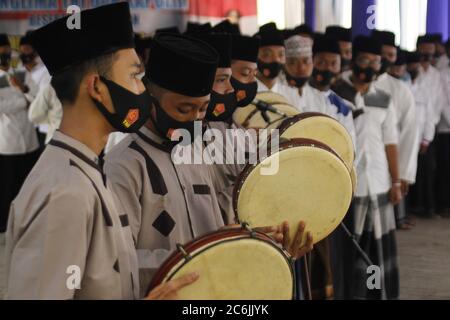 Madriun, Indonesia. 10 luglio 2020. Alcuni studenti hanno aggiunto strumenti di tamburello per accogliere i funzionari ospiti durante la visita del comandante del maresciallo dell'esercito nazionale indonesiano Hadi Tjahjanto con il capo della polizia nazionale indonesiana Idaham Aziz e il governatore orientale di Giava Khofifah Indar Parawansa Pondok Pesantren Supulul Huda Kembangsawit nel distretto di Kebonsari, Regency Madiun (Foto di Ajun Ally/Pacific Press) Credit: Pacific Press Agency/Alamy Live News Foto Stock