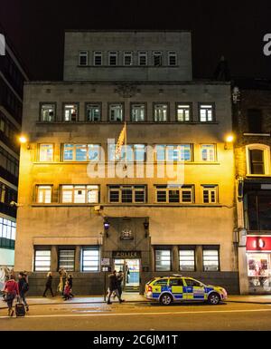 Tramonto alla stazione di polizia di Bishopsgate con le auto della polizia parcheggiate all'esterno, Londra, Regno Unito Foto Stock