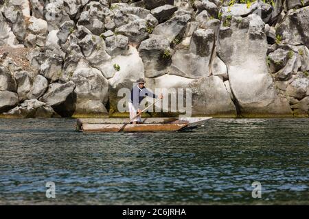 Guatemala, Dipartimento di Solola, Santiago Atitlan, un uomo Maya in abito tradizionale pagaia il suo cayuco sul lago Atitlan vicino Santiago Atitlan, Guatemala. Foto Stock