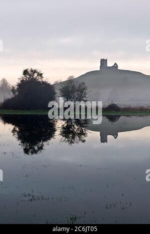 Vista invernale di prima mattina del Burrow Mump a Burrowbridge sui livelli del Somerset con il suo riflesso nelle acque alluvionali di Southlake Moor. Foto Stock