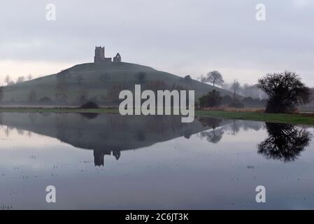 Vista invernale di prima mattina del Burrow Mump a Burrowbridge sui livelli del Somerset con il suo riflesso nelle acque alluvionali di Southlake Moor. Foto Stock