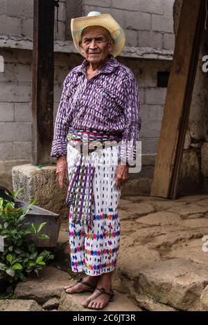 Guatemala, Dipartimento di Solola, San Pedro la Laguna, uomo Maya di 90 anni in abito tradizionale si trova di fronte alla sua casa. Foto Stock