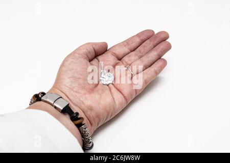 L'elemento gallio che si fonde in una mano in laboratorio. Foto Stock