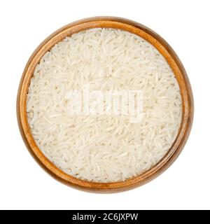 Riso Basmati bianco in ciotola di legno. Varietà di riso con grani lunghi e sottili e odore e sapore aromatico, tradizionalmente dal subcontinente indiano. Foto Stock