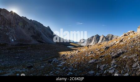 Un backpacker sale RAID/Bonneville Pass mentre il sole sorge sulle vette ad est. Wind River High Route nel Wind River Range del Wyoming. Foto Stock