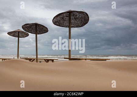 I tavoli coperti di sabbia sulla spiaggia di Egmont aan Zee, Paesi Bassi. La spiaggia senza turisti stranieri dopo la pandemia coronavirus. Foto Stock