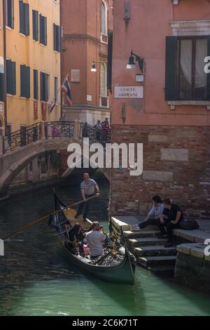 Venezia, Italia - 20 Aprile 2019: stretto canale con gondole e case storiche, in una bella giornata di sole. Foto Stock