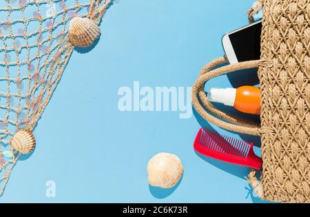 Vista dall'alto di oggetti sulla spiaggia su sfondo blu. Concetto di estate e vacanza. Foto Stock