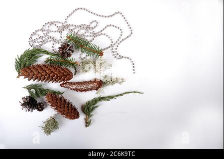 Mix casuale di coni di pino, coni di abete rosso, lichene, ginepro e rametti di abete rosso. Girland d'argento di palle d'argento. Copiare lo spazio sul lato destro dell'immagine. Foto Stock