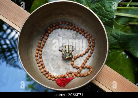 Ganesha seduto in una ciotola di meditazione con un maschio intorno a lui. Foto Stock