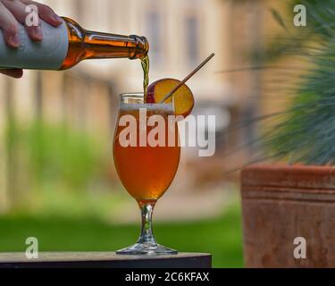 Cocktail estivo di birra artigianale non alcolica, pompelmo e pesca versato in un bicchiere Foto Stock