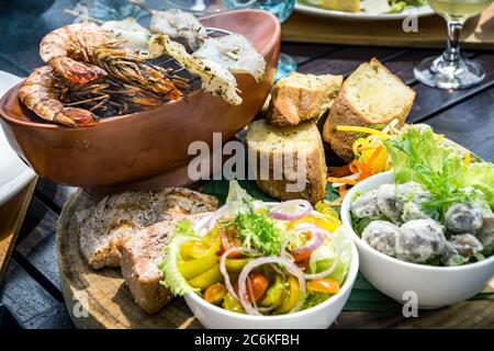 Piatti tradizionali balinesi di mare con insalata e pane a Bali, Indonesia Foto Stock