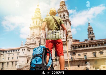 Giovane pellegrino zaino in spalla in piedi sulla piazza Obradeiro (piazza) - la piazza principale di Santiago de Compostela come una fine del suo Camino de Santiago p Foto Stock