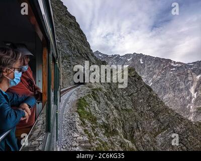 Chamonix, Chamonix Mont Blanc, Francia. 10 luglio 2020. I passeggeri mascherati a bordo della funivia del Monte Bianco ammirano le attrazioni turistiche mentre il treno a ingranaggi di montagna si snoda sulle montagne lungo la strada per Nid d'Aigle vicino al ghiacciaio Bionnassay. Credit: Sachelle Babbar/ZUMA Wire/Alamy Live News Foto Stock