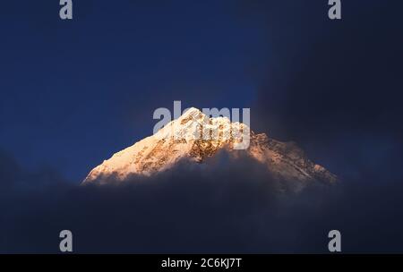 Nuppse 7861m montagna picco tramonto sera Lobuche insediamento vista coperto di neve, ghiaccio e nuvole nel Parco Nazionale Sagarmatha. Campo base Everest (EB Foto Stock