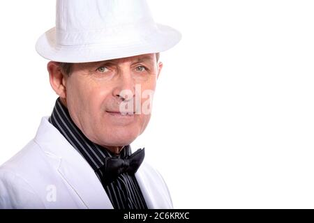 Attraente uomo anziano vestito di bianco con cappello e stile elegante Foto Stock