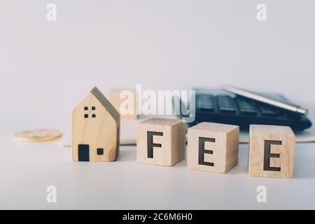 Parola di imposta su cubo di legno con oggetti come moneta d'oro, calcolatrice e mini casa modello behide bianco fondo pulito. Business prestito finanziario proprietà conc Foto Stock