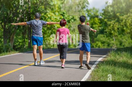 Padre madre e figlio adulto si esercitano nel parco Foto Stock