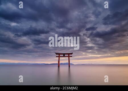 Foto a lunga esposizione del santuario Shirahige porta Torii al tramonto sul lago Biwa, Prefettura di Shiga, Giappone Foto Stock