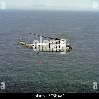 1976 - un'aria-aria - Vista laterale destra di un elicottero anti-sommergibile Squadron 6 (HS-6) SH-3 Sea King elicottero con ASQ-81 la rivelazione di anomalie magnetiche (MAD) ingranaggio sospesi al di sotto di esso durante le azioni di formazione al largo della costa della California del Sud. Foto Stock
