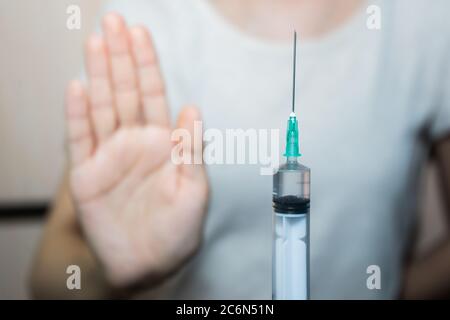 Interrompere le vaccinazioni. Una siringa nella mano del medico e un paziente dice di no Foto Stock