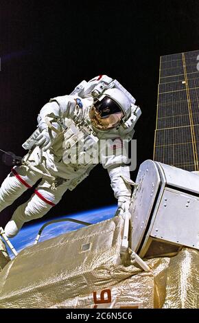 (4-15 dicembre 1998) --- astronauta Jerry L. Ross, specialista di missione STS-88, è raffigurato durante una delle tre passeggiate spaziali che sono state condotte sulla missione di undici giorni. Appollaiato alla fine del braccio del sistema di manipolazione remota (RMS) di Endeavor, l'astronauta James H. Newman, specialista della missione, ha registrato questa immagine. Foto Stock