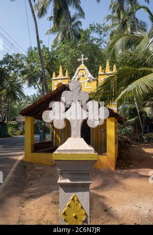 Morjim, India 14 dicembre 2019: Vista di strada con chiesa, palme. Cattedrale Chiesa Foto Stock