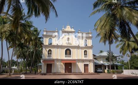 Morjim, India 14 dicembre 2019: Vista di strada con chiesa, palme. Cattedrale Chiesa Foto Stock