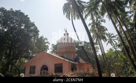 Morjim, India 14 dicembre 2019: Un piccolo tempio buddista in Asia, tra le palme Foto Stock