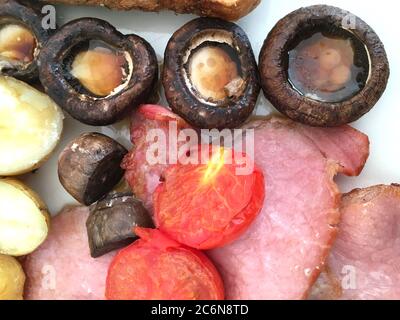 Colazione inglese tradizionale con pancetta, funghi, pomodori e patate Foto Stock