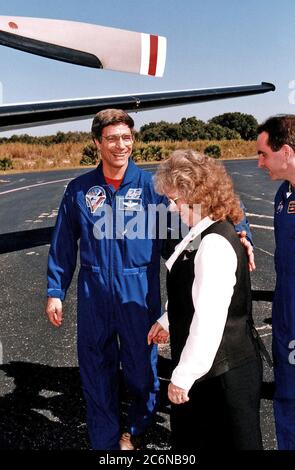 Ritorno astronauta della NASA ed ex membro dell'equipaggio Mir 22 John E. Blaha (a sinistra), mette il braccio intorno a sua moglie, Brenda, mentre si preparano a partire con l'equipaggio STS-81 per Johnson Space Center gennaio 23 dalla Skid Strip presso la stazione aerea di Cape Canaveral. Patrick McGinnis della NASA è sulla destra. L'equipaggio della STS-81 è arrivato al KSC a bordo dello Space Shuttle Atlantis il 22 gennaio per concludere la quinta missione di attracco di ShuttleMir e tornare a Blaha sulla Terra dopo quattro mesi nello spazio Foto Stock