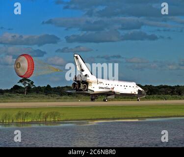 KENNEDY SPACE CENTER, Fla. -- lo scivolo di trascinamento orbiter si dispiega dopo che l'orbiter dello Space Shuttle Atlantis atterra sulla pista 15 del KSC Shuttle Landing Facility (SLF) alla conclusione della missione STS-86 di quasi 11 giorni. La marcia principale è stata toccata alle 17:55:09 EDT, 6 ottobre 1997, con un tempo non ufficiale di 10 giorni, 19 ore, 20 minuti e 50 secondi. Le prime due opportunità di atterraggio del KSC di domenica sono state sventate a causa delle preoccupazioni del tempo. La 87a missione Space Shuttle fu il 40° atterraggio dello Shuttle al KSC. Domenica sera il programma Space Shuttle ha raggiunto una tappa fondamentale: Foto Stock