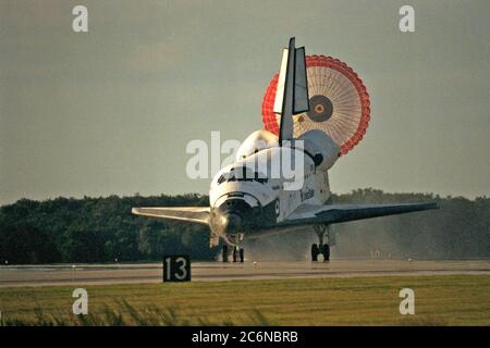 KENNEDY SPACE CENTER, Fla. -- lo scivolo di trascinamento orbiter si dispiega dopo che l'orbiter dello Space Shuttle Atlantis atterra sulla pista 15 del KSC Shuttle Landing Facility (SLF) alla conclusione della missione STS-86 di quasi 11 giorni. La marcia principale è stata toccata alle 17:55:09 EDT, 6 ottobre 1997, con un tempo non ufficiale di 10 giorni, 19 ore, 20 minuti e 50 secondi. Le prime due opportunità di atterraggio del KSC di domenica sono state sventate a causa delle preoccupazioni del tempo. La 87a missione Space Shuttle fu il 40° atterraggio dello Shuttle al KSC. Domenica sera il programma Space Shuttle ha raggiunto una tappa fondamentale: Foto Stock