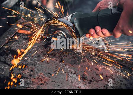 La formazione di scintille da la rotazione ed il taglio di metallo da elettrico macchina sezionatrice Foto Stock