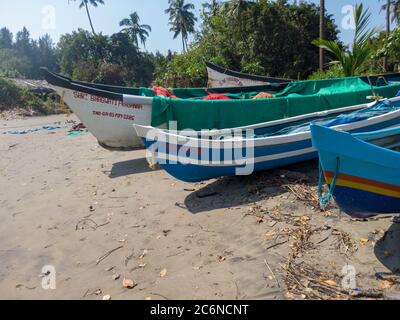 Morjim, India 14 dicembre 2019: Imbarcazione vuota sulla spiaggia di sabbia in giornata intensa. Grande vecchia barca bianca sul mare sabbioso pronta a navigare in giornata sulla spiaggia Foto Stock