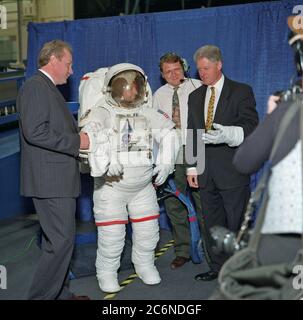 (14 aprile 1998) --- il presidente Bill Clinton prova su un guanto dalla tuta spaziale dell'unità di mobilità extraveicolare (EMU) dello Space Shuttle durante una visita del 14 aprile al Johnson Space Center (JSC). Nella tuta c'è Amy Ross, un ingegnere JSC. Altri sono William E. (Bill) Spenny (a sinistra) della filiale EVA e Spacesuit Systems della divisione Crew and Thermal Systems, direzione Engineering; e Stephen N. Anderson (seconda a destra) di ILC. Foto Stock