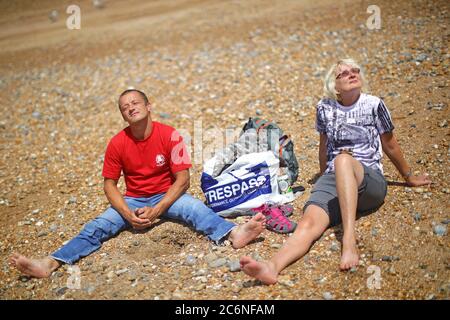La gente gode del sole e del caldo tempo sulla spiaggia di Brighton. Foto Stock