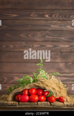 Pomodori lunghi di prugne su tavola di legno. Stile ucraino paese. Concetto di prodotto naturale. Posizione vuota per il testo. Foto Stock