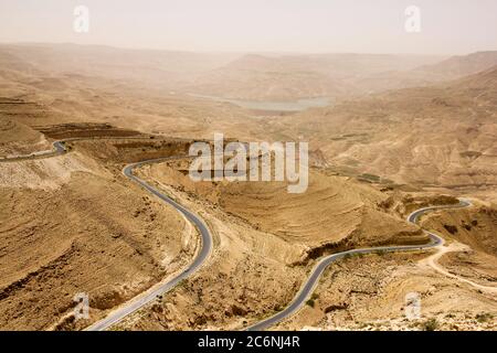 Autostrada curvilinea nella Great Rift Valley con paesaggio desertico in Giordania. Wadi Mujib King's Road area Foto Stock
