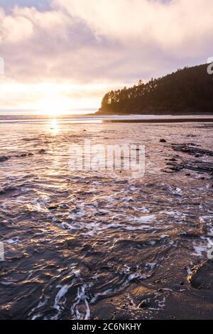 Nuvole colorate che si riflettono sull'acqua a bassa marea vista da Hunters Cove nella costa meridionale dell'Oregon Foto Stock