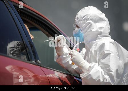 Bucarest / Romania - 11 luglio 2020: Un operatore sanitario utilizza un test CPR (bocca e tampone nasale) su una persona all'interno di un'auto per determinare la presenza o l'abuso Foto Stock