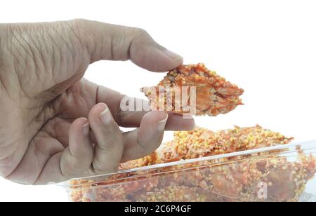 Cucina e cibo, mano di tenuta croccante fritto di granchi minuscoli isolato su sfondo bianco. Uno dei più famosi snack e antipasti in Thailandia. Foto Stock