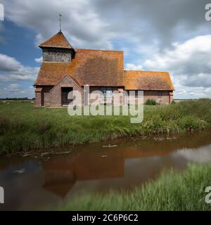 La chiesa di St Thomas à Becket si rifletteva in un canale vicino Brookland, Romney Marsh, Inghilterra Foto Stock