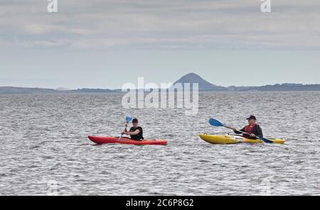 Portobello, Edimburgo, Scozia, Regno Unito 11 luglio 2020. La temperatura fresca al mattino sale a 18 gradi nel pomeriggio con la brezza fresca. Gli sport acquatici su tavole da paddle e kayak sono diventati più popolari nel corso dei tre mesi della pandemia di Coronavirus, come persone di tutte le età hanno avuto più tempo libero. Foto Stock